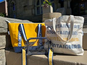 WVU tote bags in front of Stewart Hall